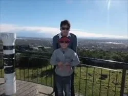 サインオブタカヘ展望台で、クライストチャーチの街並みを背景に男性と男の子が立っている