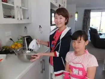 お菓子作り中の学生ホームステイのゲストと女の子