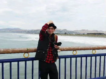 波立つニューブライトンの桟橋に立つホームステイゲストの男性