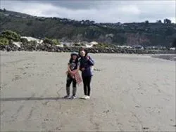 遠浅のサムナビーチの砂浜でピースをしている女性と子ども