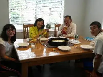 ご夫婦でホームステイをされたお二人と子供たちが食卓を囲んでいる